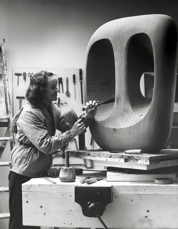 Barbara Hepworth in the Palais de Danse studio at work on the wood carving Hollow Form with White Interior, 1963. Photographed by Val Wilmer © Bowness, Hepworth Estate