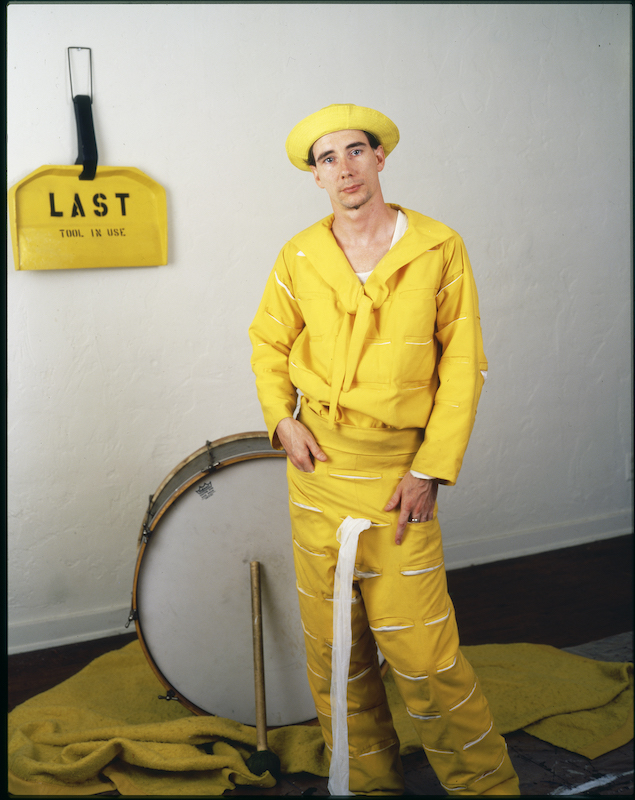 Jim McHugh portrait of Mike Kelley as The Banana Man, c.1983, with (in the background) Last Tool in Use, 1977. Enamel 73.7 × 55.3 × 7.6 Photo © Jim McHugh