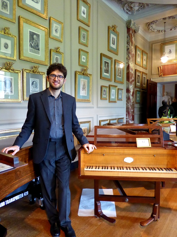 Roman Rabinovich standing by Haydn's fortepiano at Hatchlands