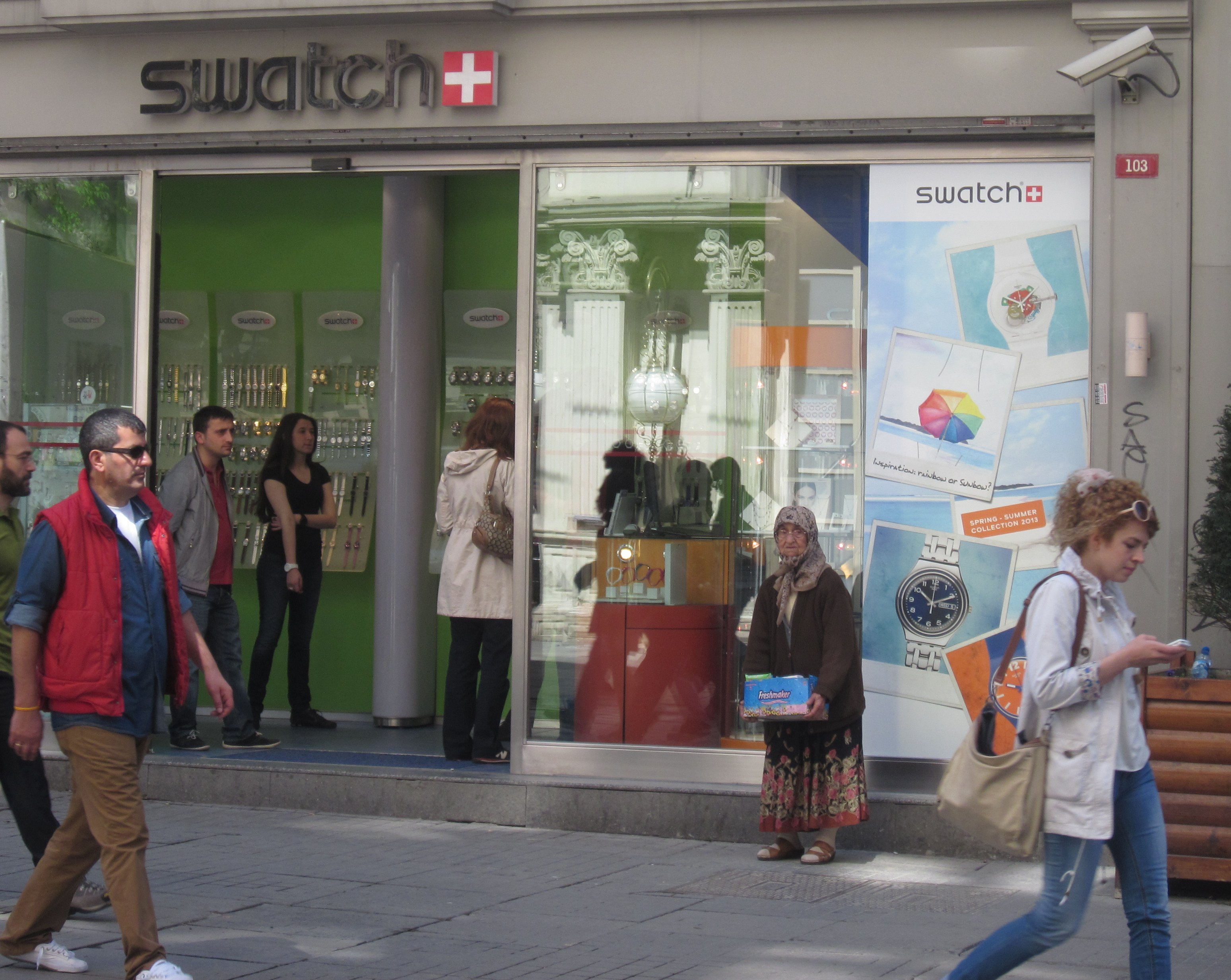 Old and new: a lottery ticket seller stands guard by the Swatch shop on Istanbul's İstiklal Caddesi