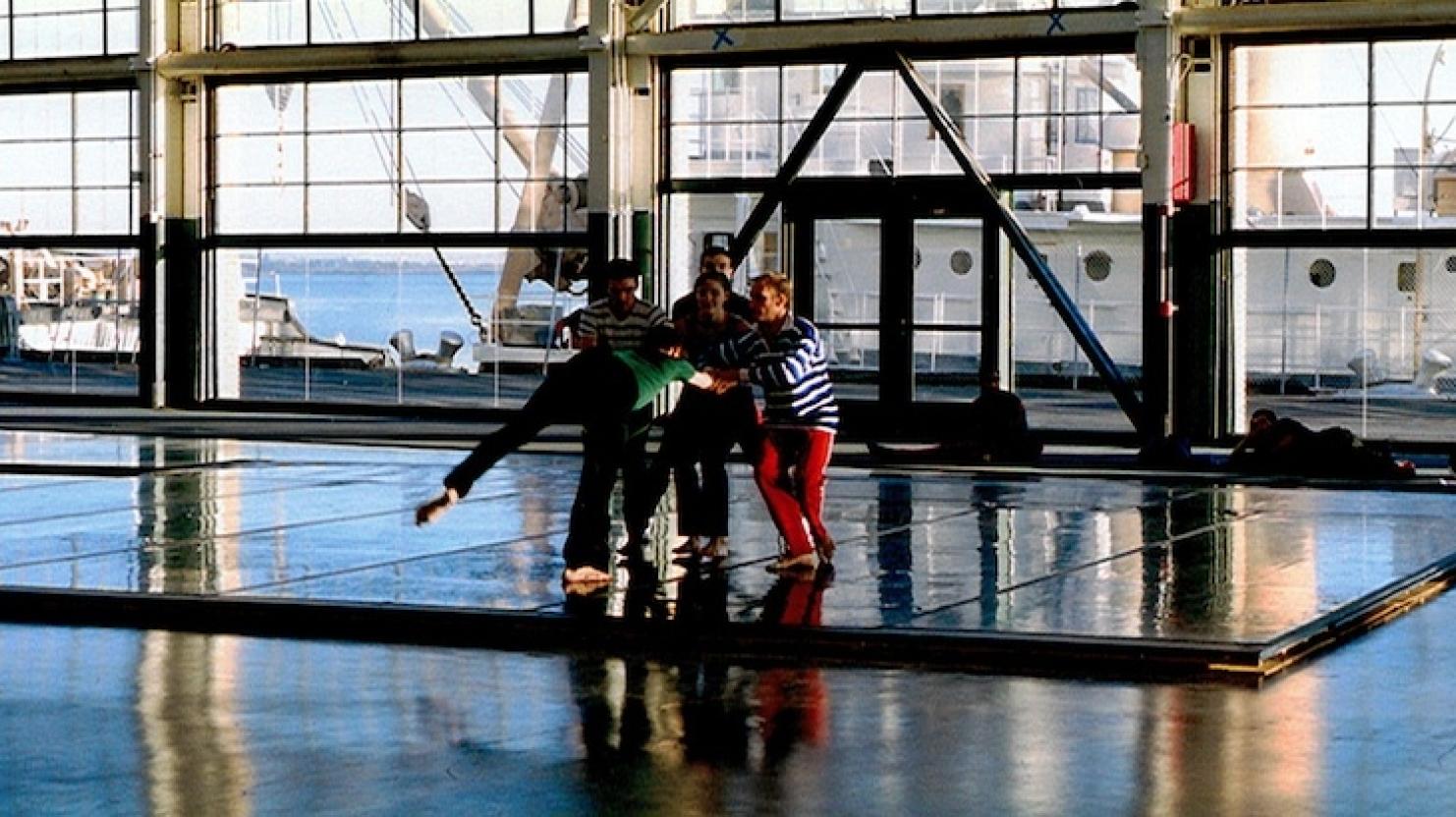 'Against the light, the dancers appear like marionettes framed within grids of glass and steel'