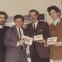 September 1964. New employee Lou Reed (right) at Pickwick Records’ offices, with fellow company songwriter Jerry Vance (far left), label exec Terry Philips (second from left) and an unknown colleague. “Let’s not die of improvement” says one of the cards they are holding. Another declares “We pay off in results…not effort.”