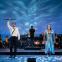 Tamino (Thomas Atkins) and Pamina (Gemma Summerfield) walk through water with the support of Leo McFall and orchestra
