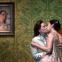 Knight of the rose Octavian (Kate Lindsey) kisses unwilling bride Sophie (Elizabeth Sutphen) beneath the portrait of her deceased mother