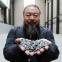 Ai Weiwei holding some of his sunflower seeds at Tate Modern